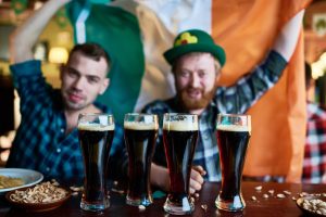 Friends drinking beer together on St.Patrick's Day during a group vacation tour 