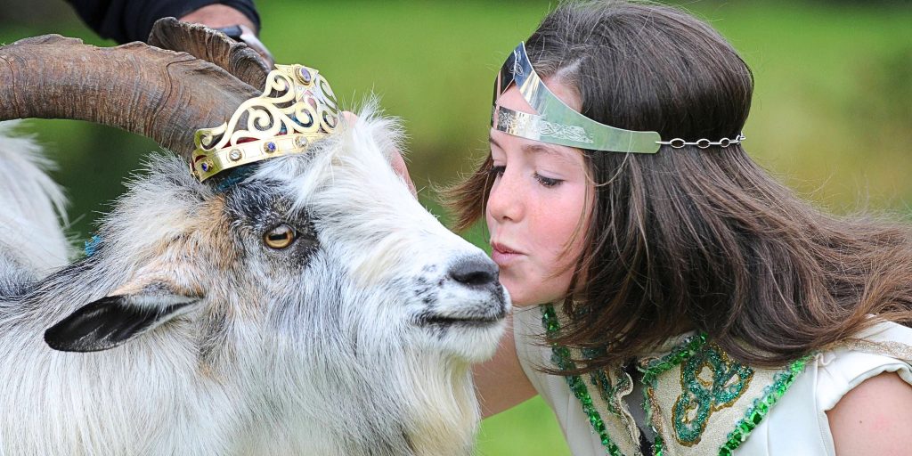 Young girl kissing 'Puck' the goat