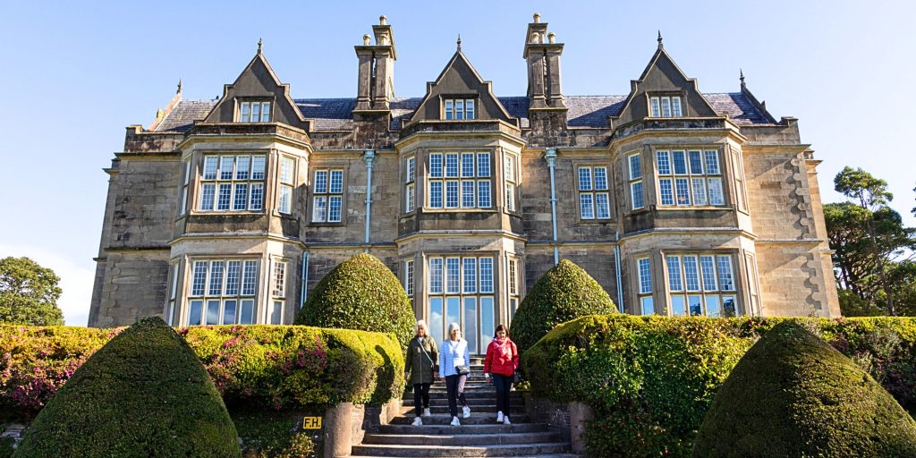 People walking down the exterior steps of Muckross House